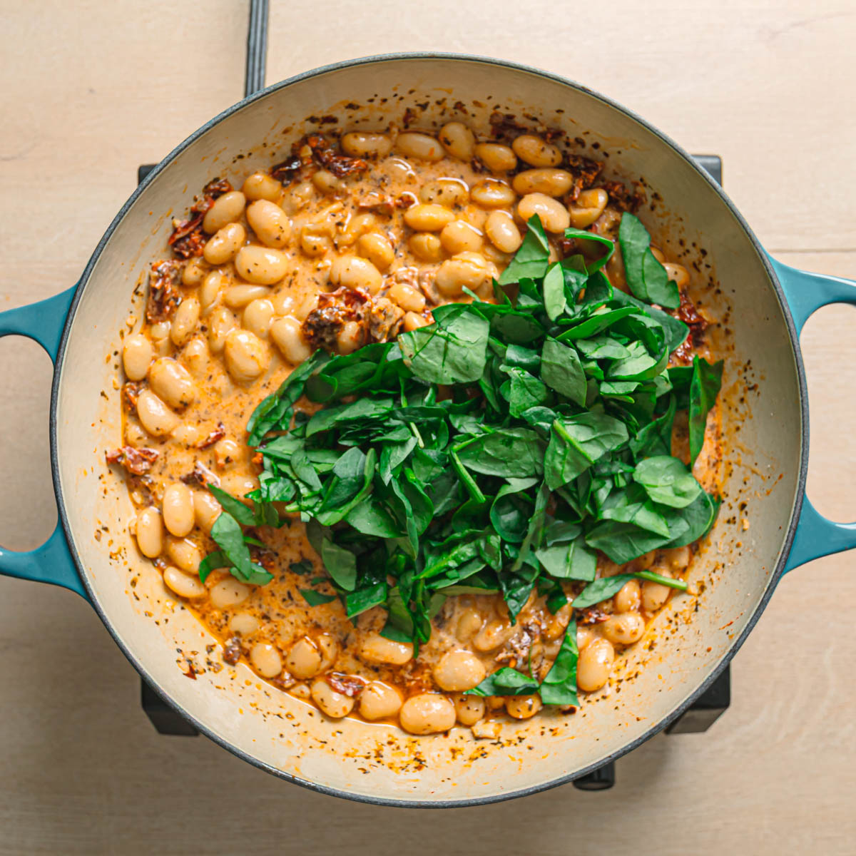 Parmesan cheese and fresh spinach stirred into marry me butter beans sauce.